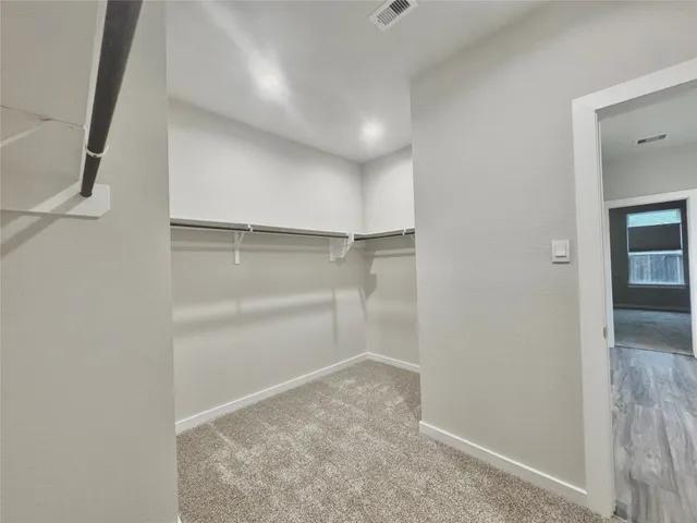 a view of walk in closet with empty racks