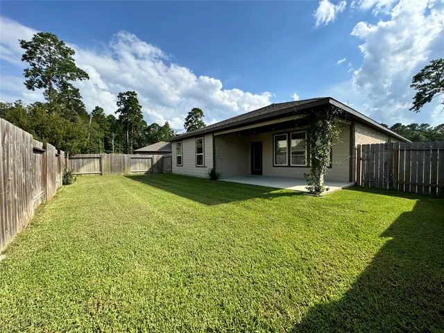 a view of a house with backyard and porch