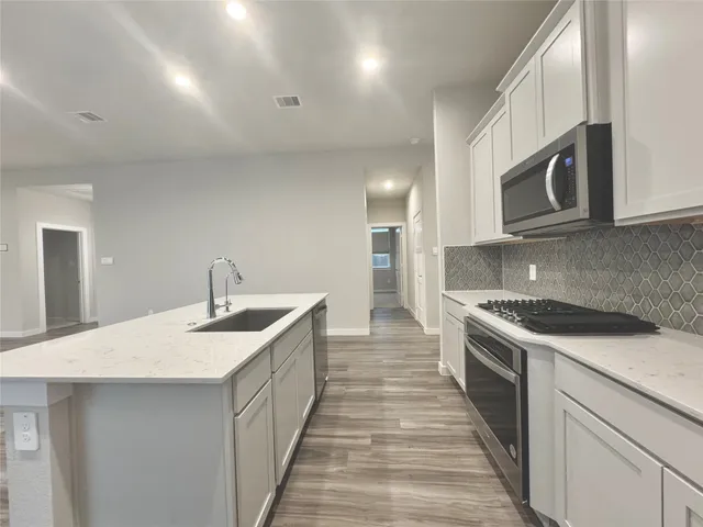 a kitchen with stainless steel appliances granite countertop a sink and stove top oven