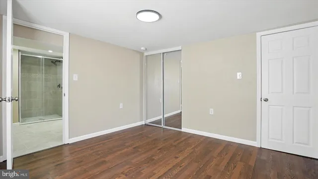 an empty room with wooden floor and entryway