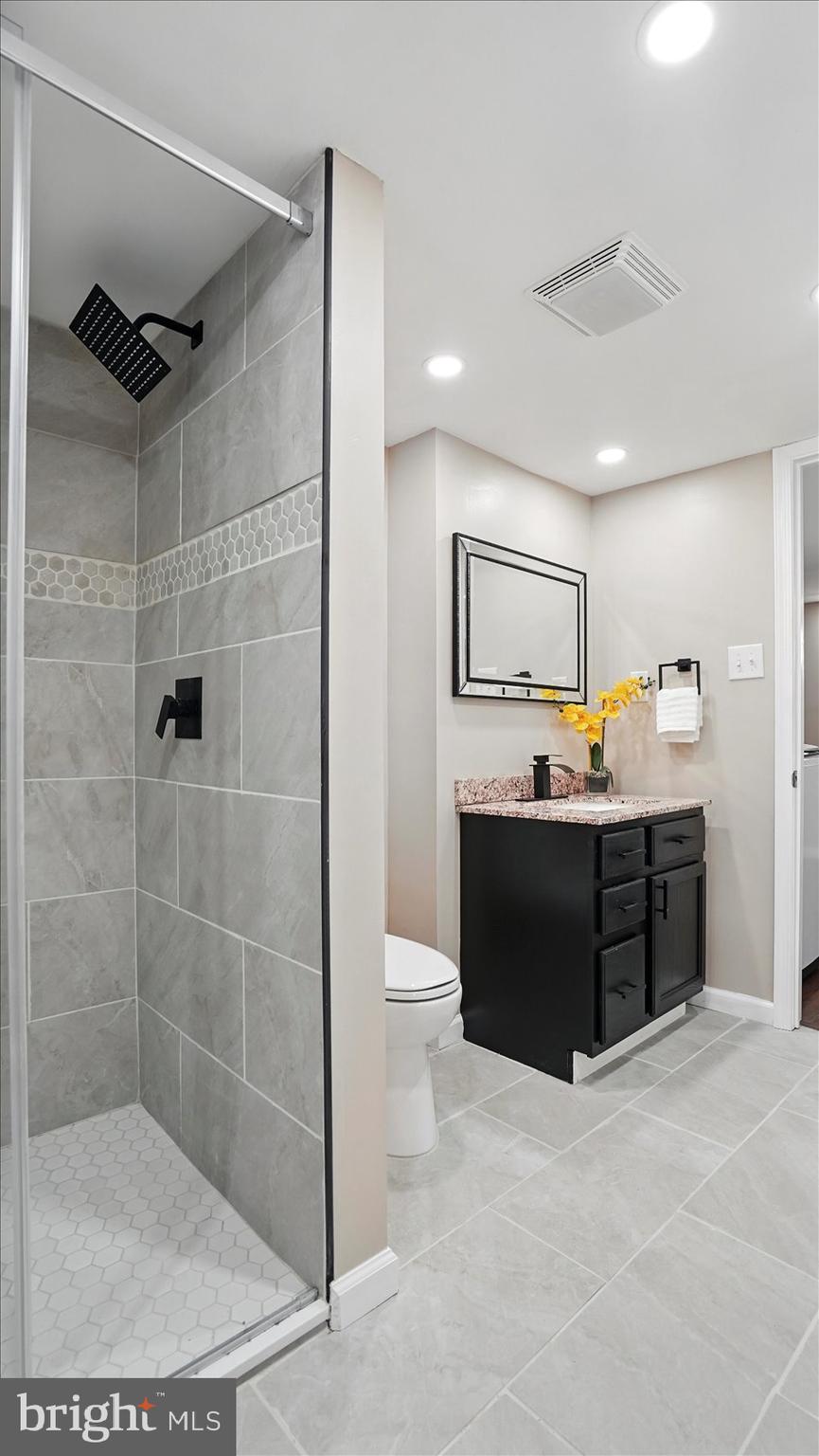 5427 Gradin Avenue Gwynn Oak, MD 21207 - Photo 18 of 24 a bathroom with a double vanity sink toilet and shower