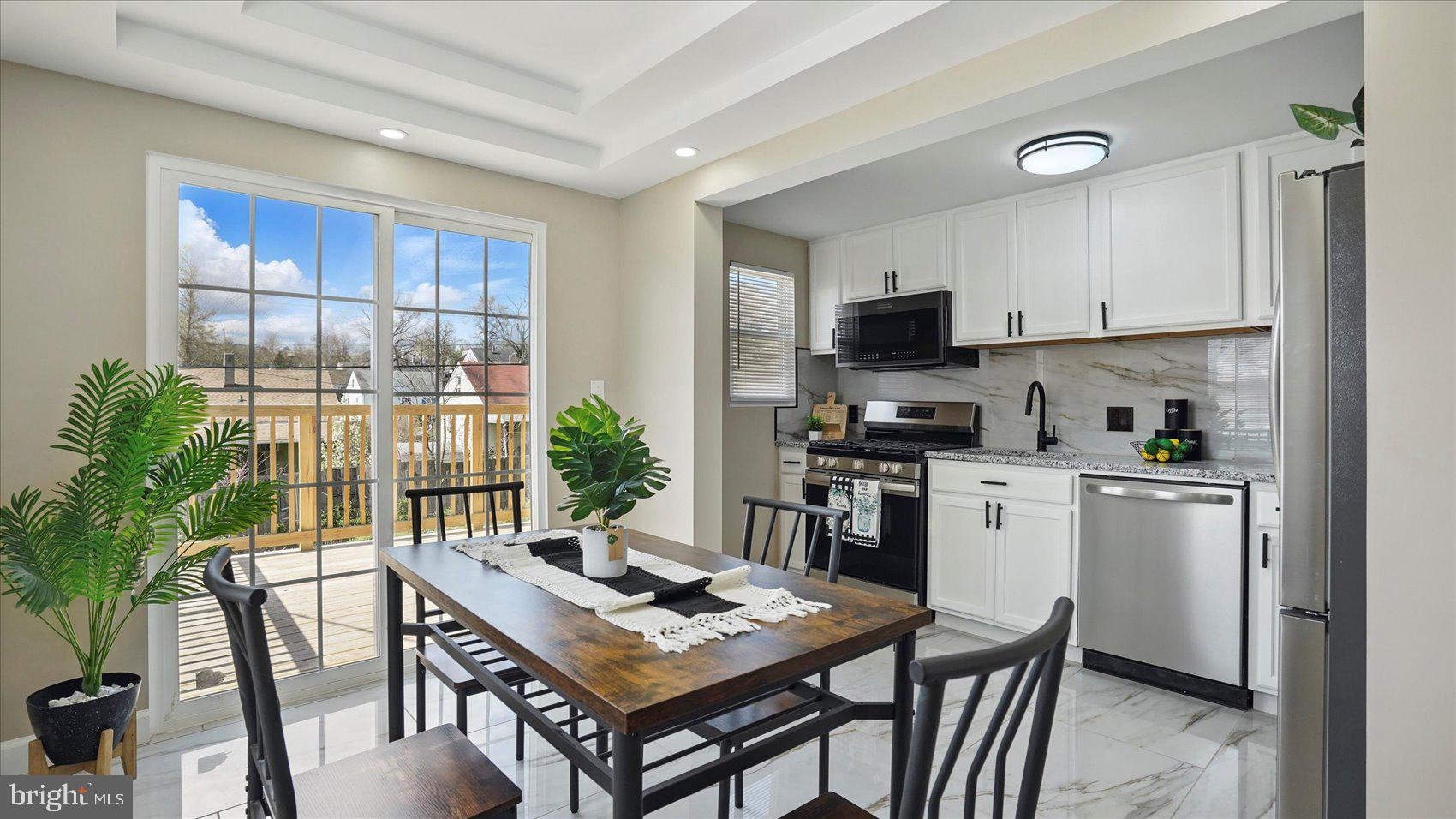 5427 Gradin Avenue Gwynn Oak, MD 21207 - Photo 24 of 24 a kitchen with a table chairs a refrigerator and a stove