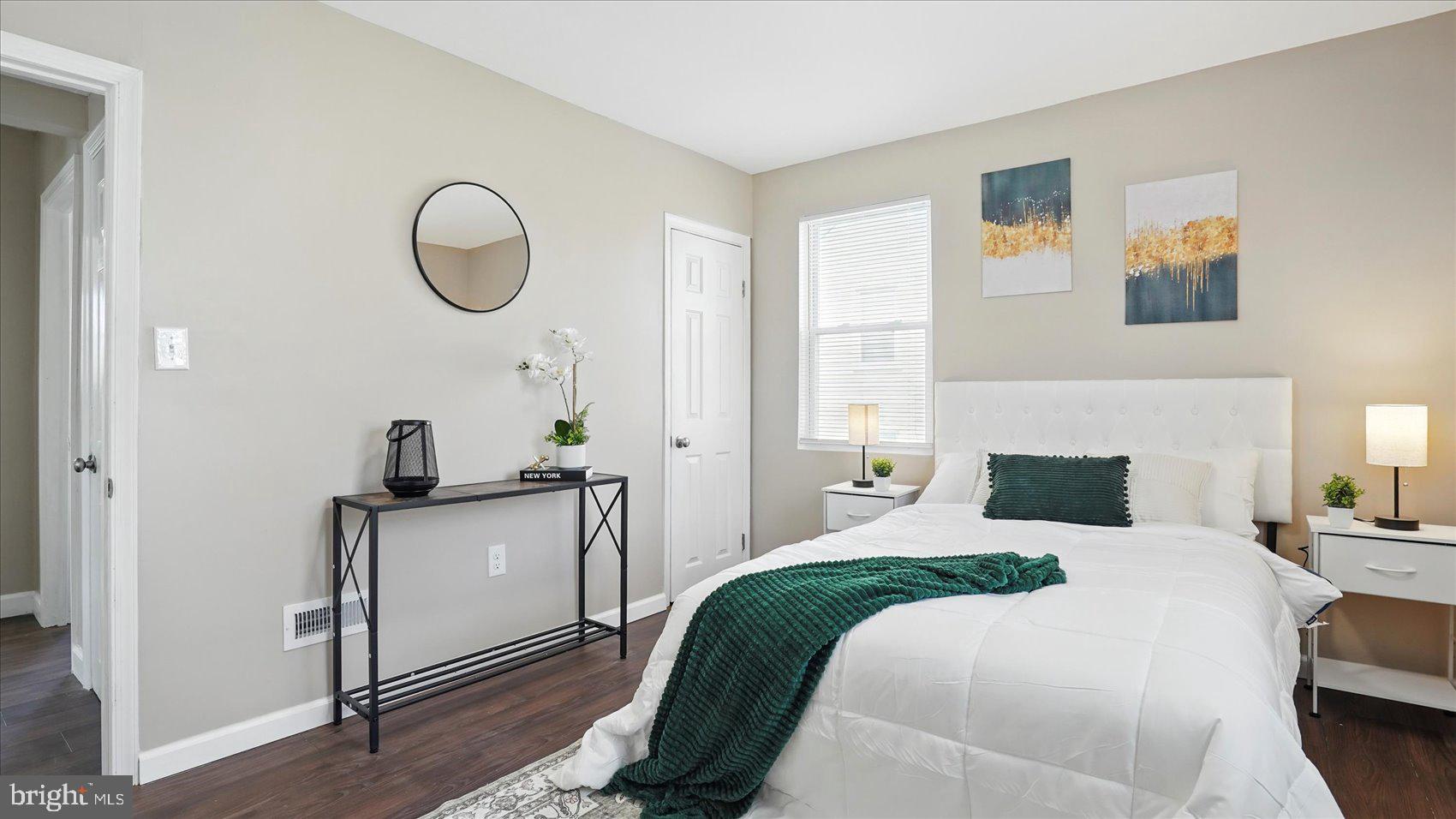 5427 Gradin Avenue Gwynn Oak, MD 21207 - Photo 9 of 24 a bedroom with a bed a mirror and a potted plant