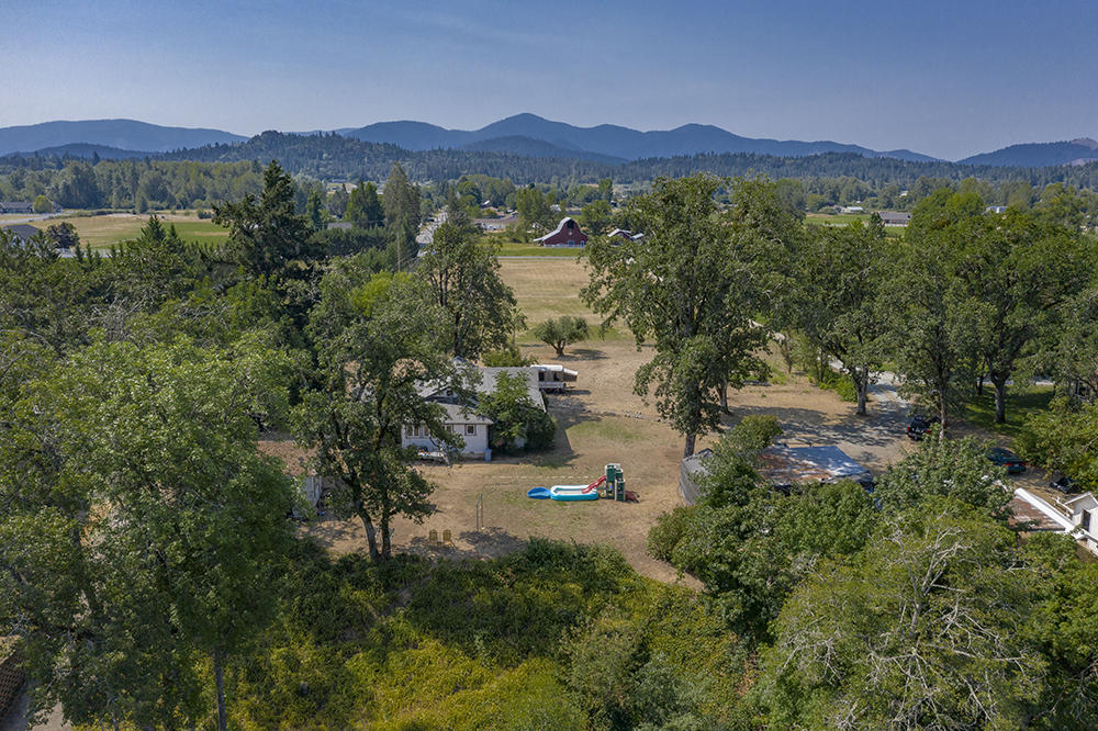 4028 Leonard Road Grants Pass, OR 97527 - Photo 3 of 26 a view of a lush green field with mountains in the background