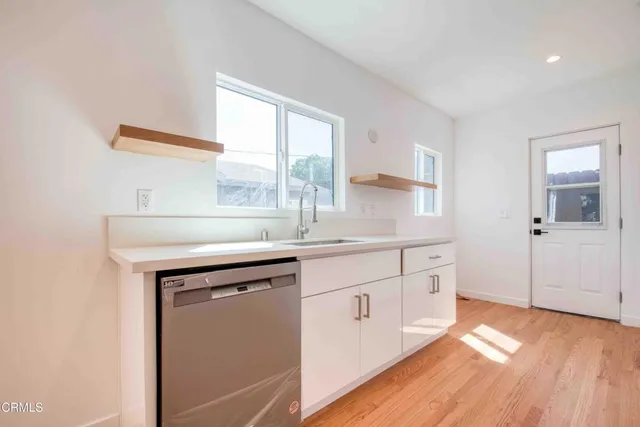 a kitchen with granite countertop a sink and cabinets
