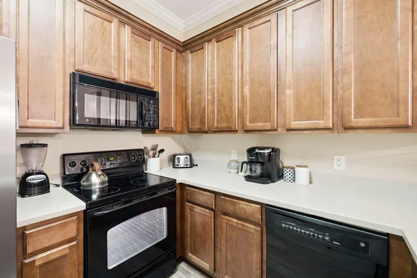 a kitchen with stainless steel appliances granite countertop white cabinets a stove a sink and dishwasher