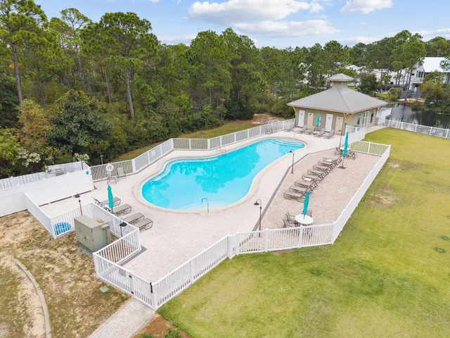 a view of a swimming pool with a table and chairs under an umbrella