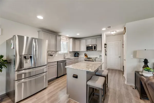 a kitchen with white cabinets and stainless steel appliances