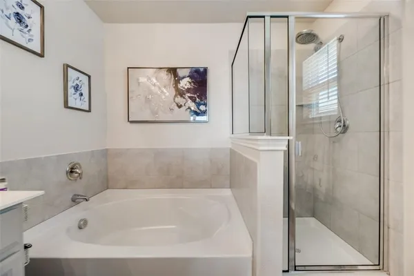 a white bath tub sitting next to a white sink and vanity