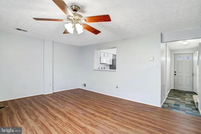 a view of empty room with wooden floor