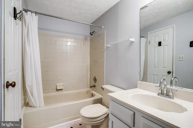 a bathroom with a sink a toilet a mirror a bathtub and shower