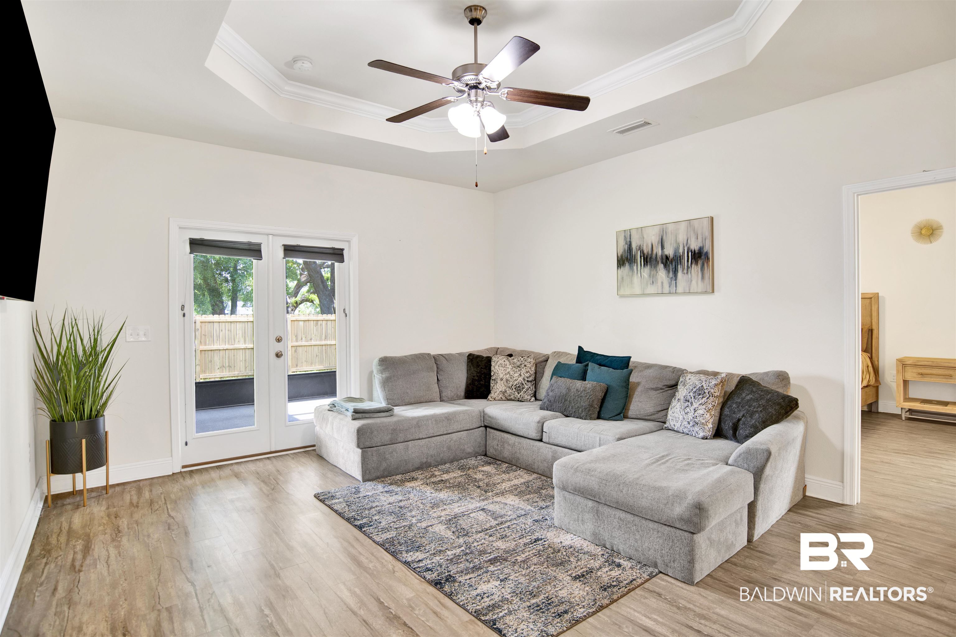1468 Surrey Loop Foley, AL 36535 - Photo 15 of 28 Living area featuring a tray ceiling, wood finished floors, a ceiling fan, french doors, and ornamental molding