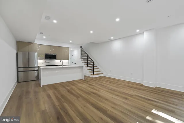 a view of kitchen with granite countertop stainless steel appliances and sink