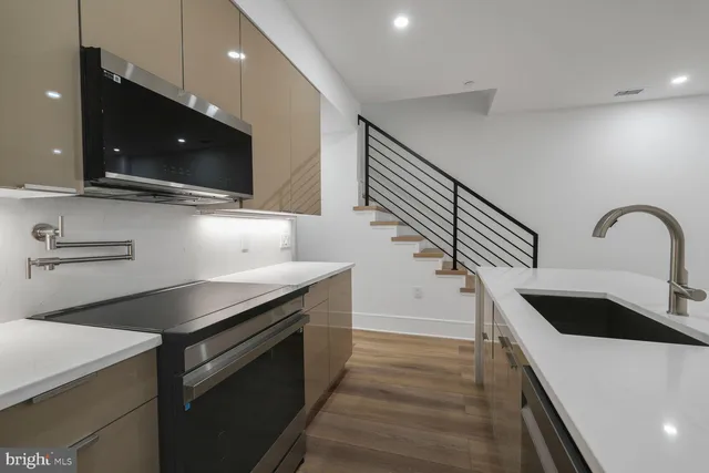 a kitchen with stainless steel appliances a sink and a microwave