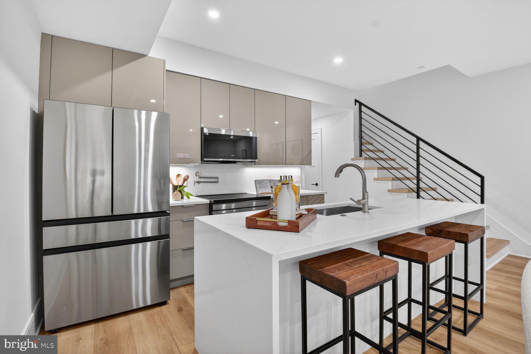 2524 41st Street Northwest, Unit 2 Washington, DC 20007 - Photo 16 of 27 a kitchen with stainless steel appliances a refrigerator a sink a stove a table and chairs