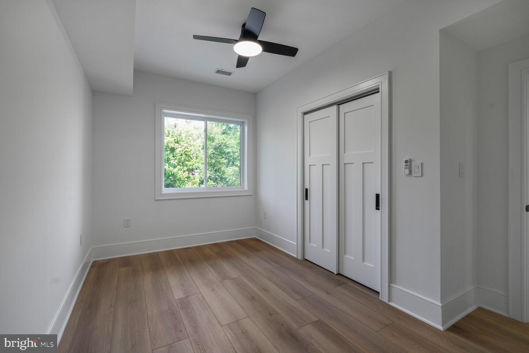 2524 41st Street Northwest, Unit 2 Washington, DC 20007 - Photo 17 of 25 an empty room with wooden floor ceiling fan and windows
