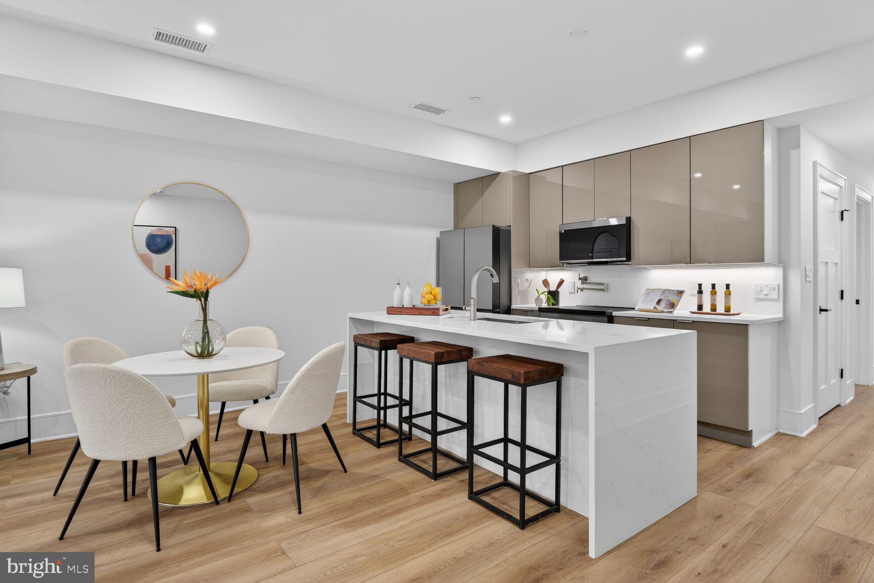 2524 41st Street Northwest, Unit 2 Washington, DC 20007 - Photo 7 of 27 a kitchen with kitchen island a dining table chairs and a refrigerator