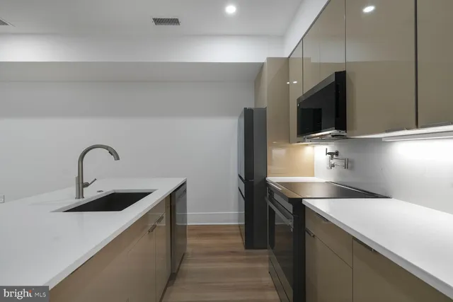 a kitchen with stainless steel appliances a sink and a stove top oven