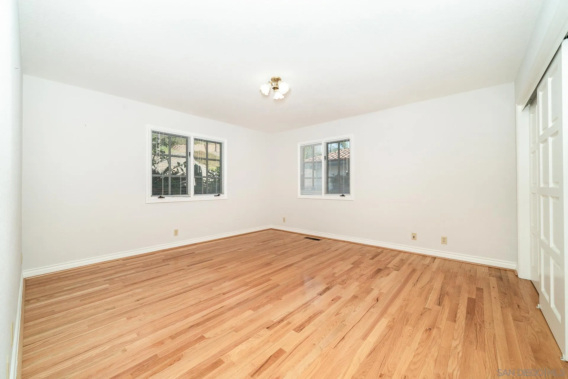 2908 Lakemont Drive Fallbrook, CA 92028 - Photo 20 of 70 an empty room with wooden floor and windows