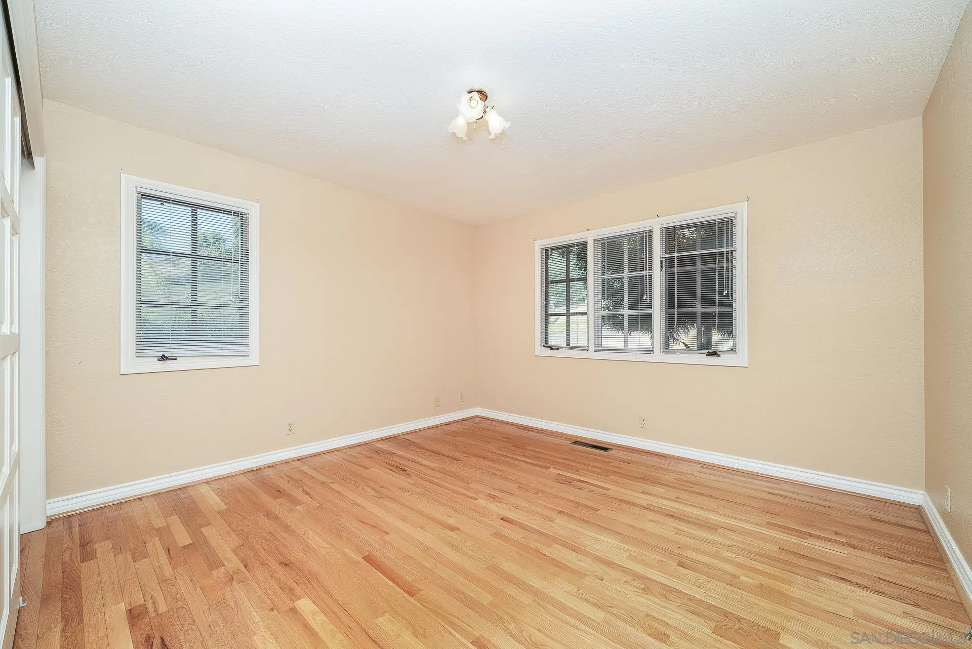 2908 Lakemont Drive Fallbrook, CA 92028 - Photo 22 of 70 a view of empty room with wooden floor and fan