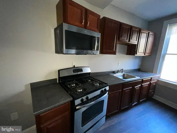 a kitchen with stainless steel appliances granite countertop a stove and a microwave