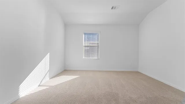 an empty room with a white cabinet and a window