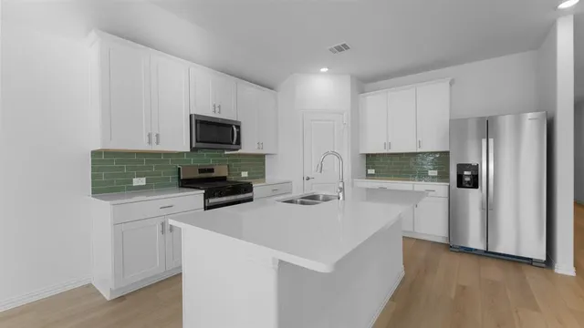 a kitchen with a refrigerator and a stove top oven
