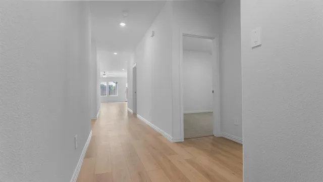 a view of a hallway with wooden floor