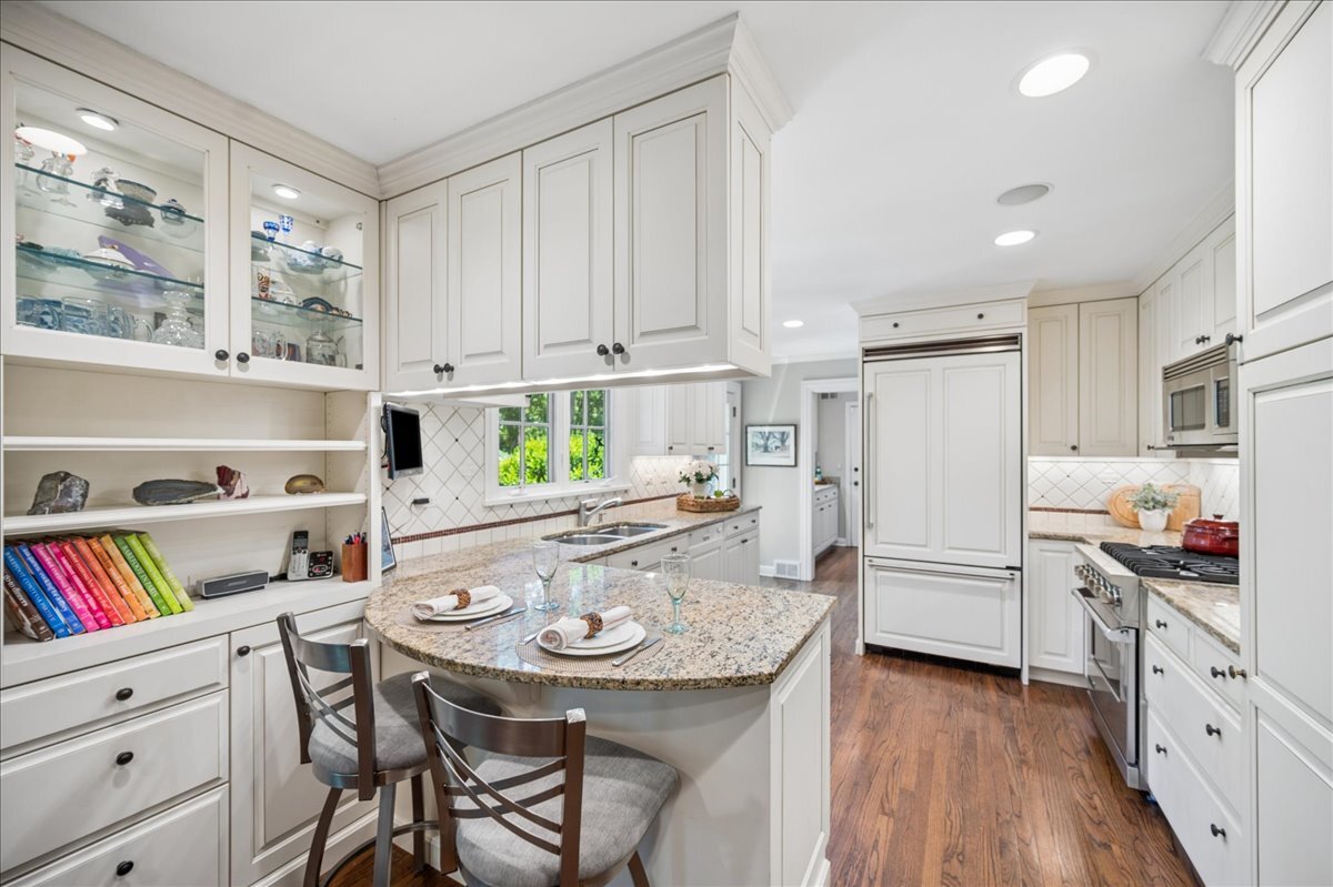 253 Summerfield Road Northbrook, IL 60062 - Photo 16 of 46 a kitchen with stainless steel appliances a white table chairs and a refrigerator