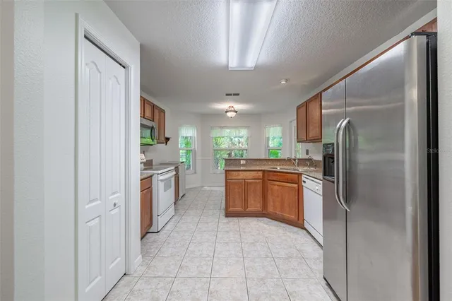 a large kitchen with a refrigerator and a sink