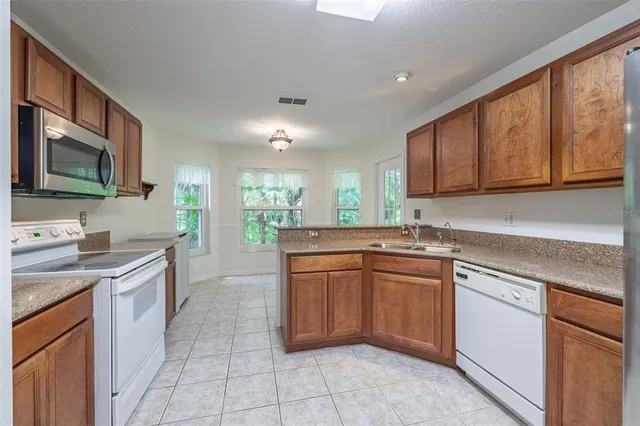 a kitchen with stainless steel appliances granite countertop a sink stove and cabinets