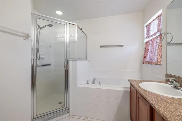 a bathroom with a granite countertop sink a mirror a shower and a bathtub