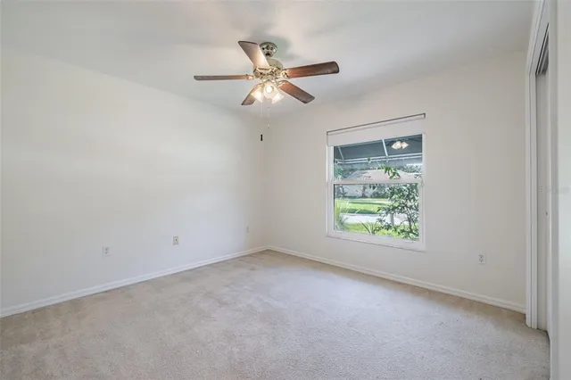 an empty room with a window and a fan