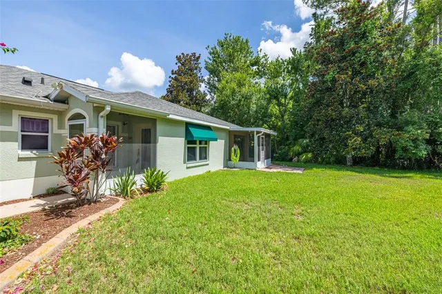 a front view of house with yard and trees around