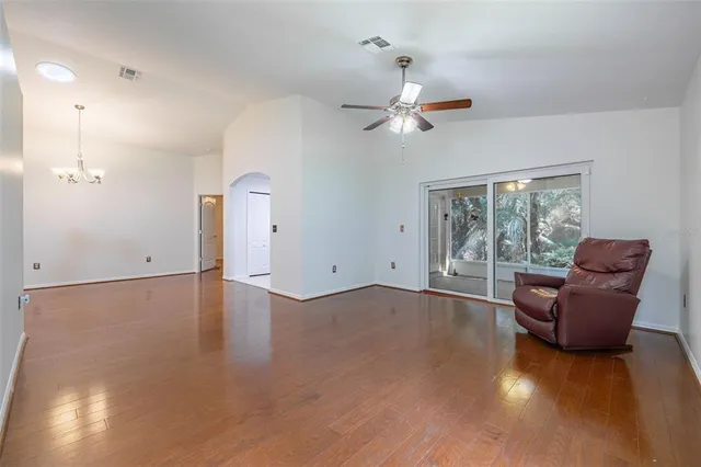 a view of a livingroom with furniture a ceiling fan and window