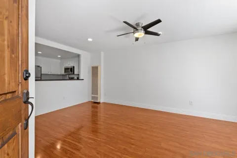 a view of a room with wooden floor and a ceiling fan