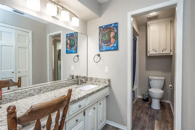 a en suite bathroom with a granite countertop sink and a mirror