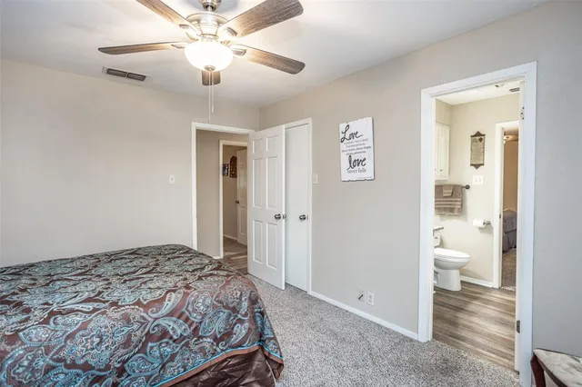 a bathroom with a granite countertop toilet sink and mirror