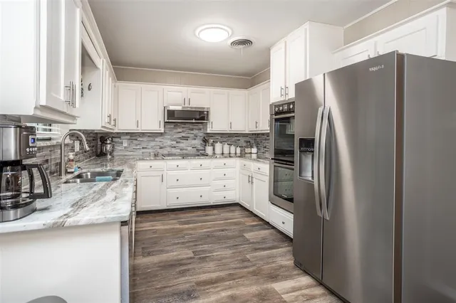 a kitchen with granite countertop white cabinets and white appliances