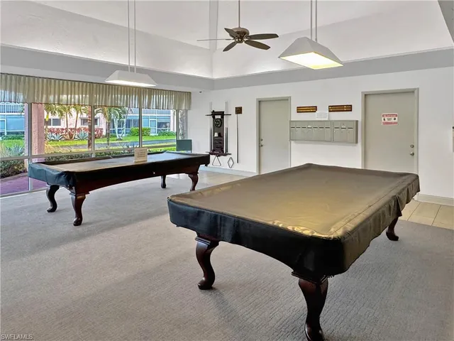 a room with pool table and windows