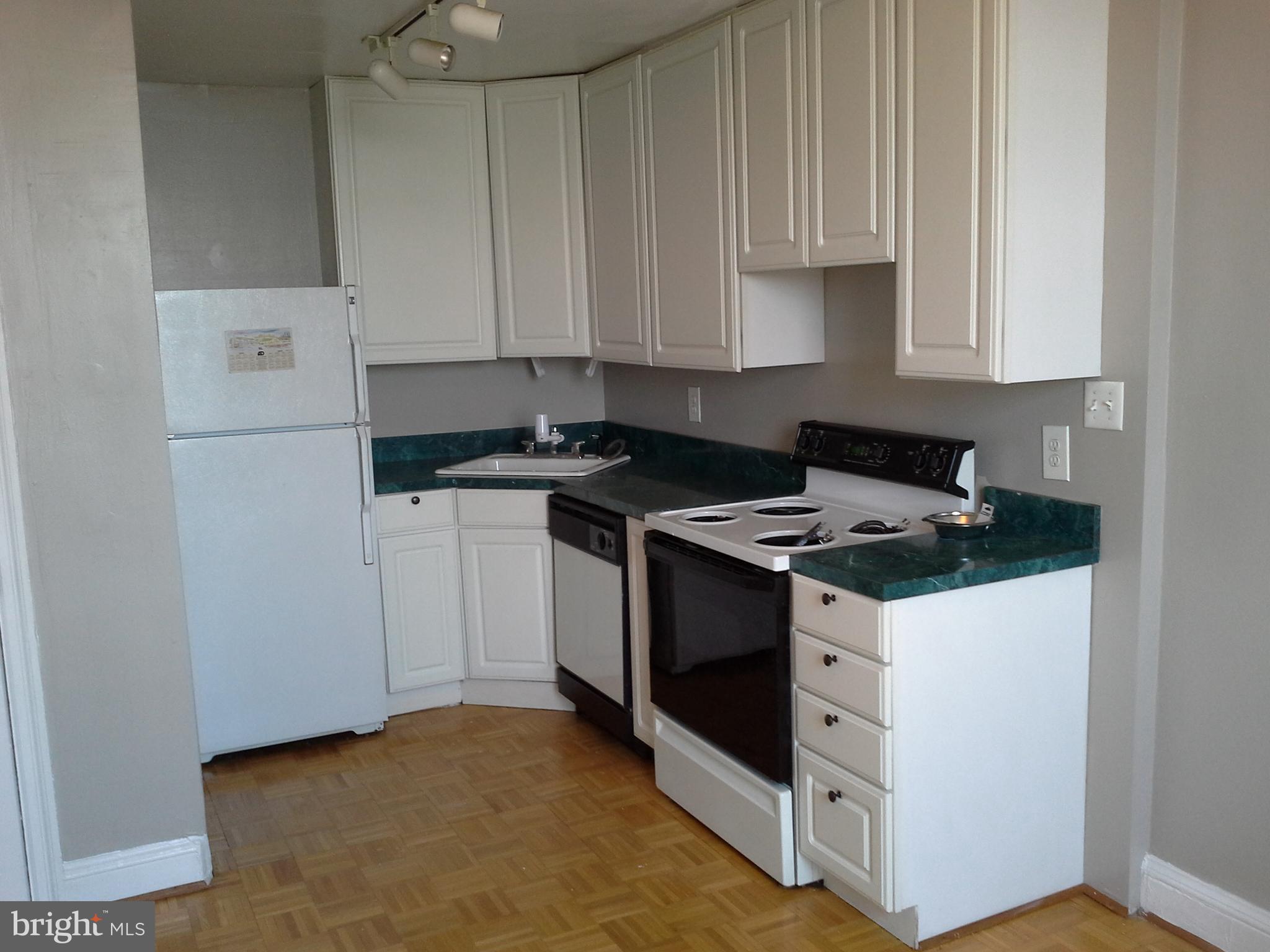 2031 Locust Street, Unit 1402 Philadelphia, PA 19103 - Photo 3 of 15 a kitchen with stainless steel appliances a stove a microwave and a sink