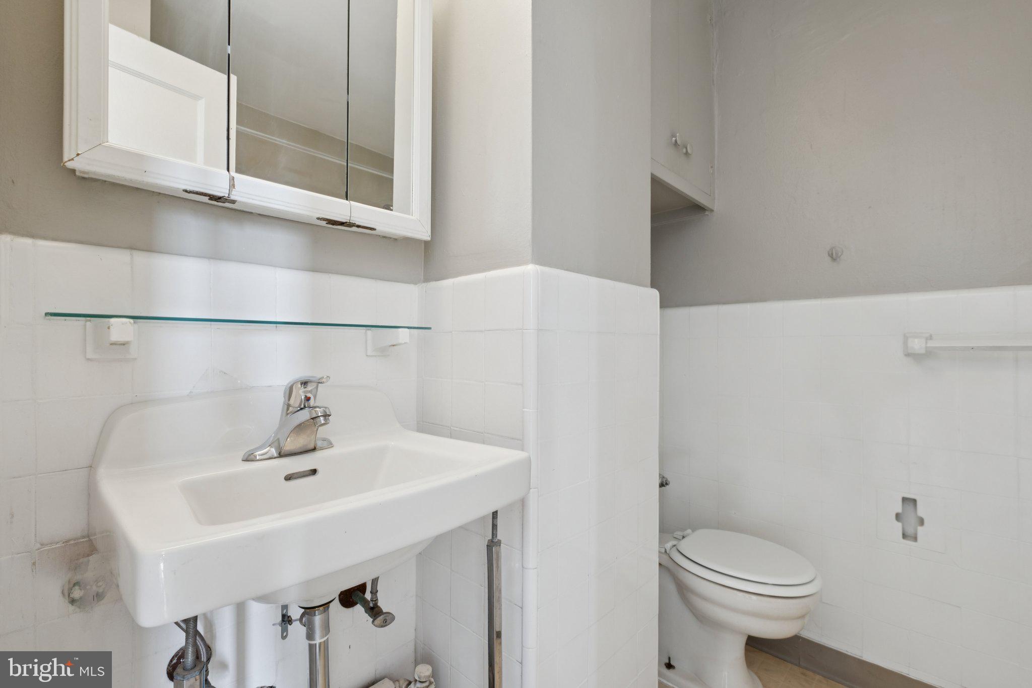 2031 Locust Street, Unit 1402 Philadelphia, PA 19103 - Photo 7 of 15 a bathroom with a sink a toilet and mirror