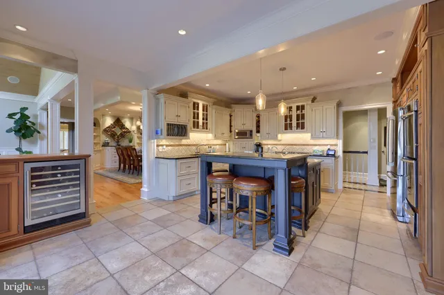 a kitchen with kitchen island granite countertop a sink counter and chairs