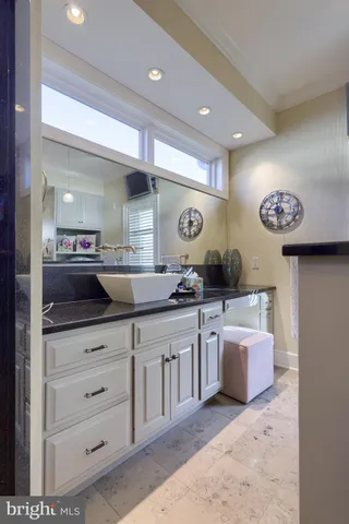 a bathroom with a granite countertop toilet sink mirror and shower