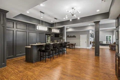 a bathroom with a granite countertop sink toilet a large mirror a shower and a mirror