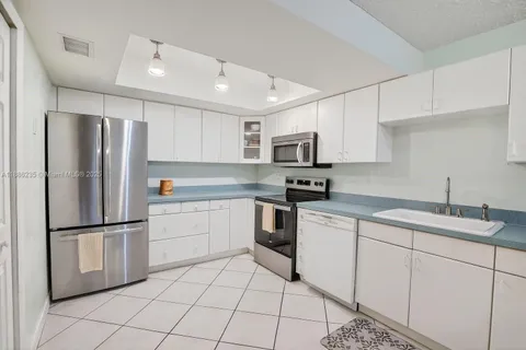a kitchen with white cabinets stainless steel appliances and a sink