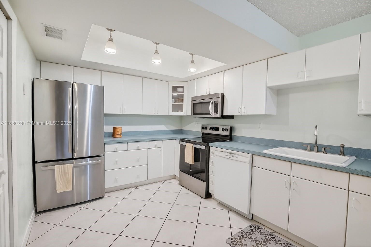 27 Madrid Lane, Unit 28 Davie, FL 33324 - Photo 11 of 34 a kitchen with white cabinets stainless steel appliances and a sink
