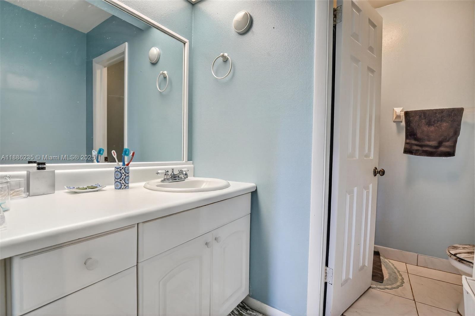 27 Madrid Lane, Unit 28 Davie, FL 33324 - Photo 15 of 34 a bathroom with a double vanity sink and mirror