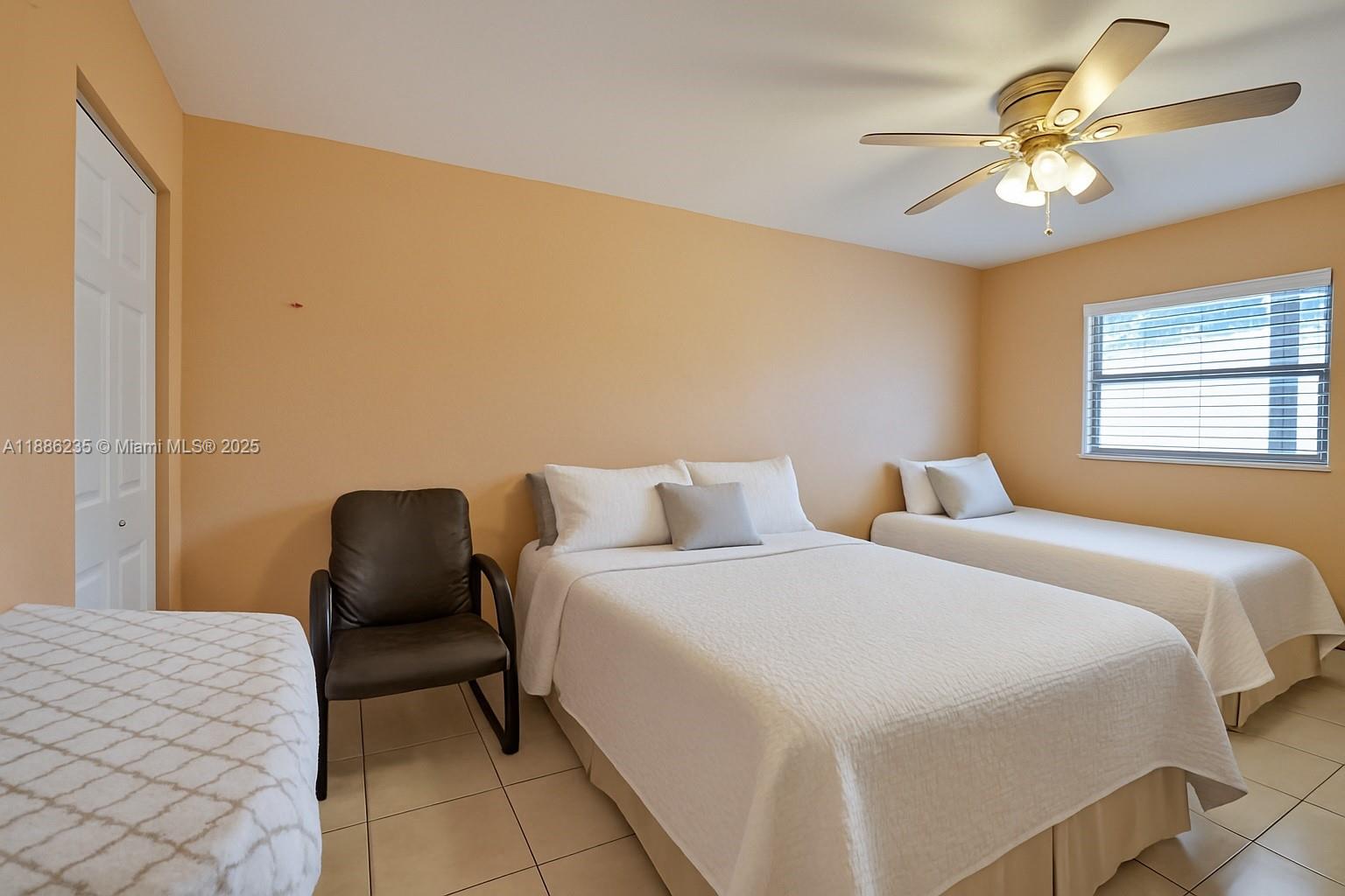 27 Madrid Lane, Unit 28 Davie, FL 33324 - Photo 19 of 34 a bedroom with a bed and a chandelier