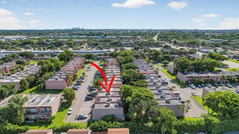 an aerial view of residential houses with outdoor space and trees